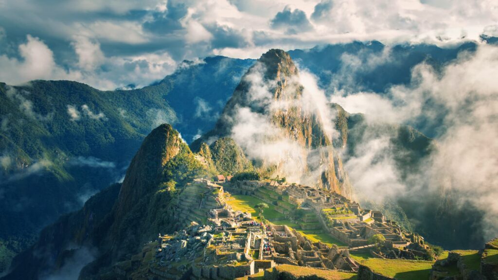 A breathtaking view of Machu Picchu, the ancient Inca citadel, nestled among the Andean mountains with misty clouds adding to its mystique - Machupicchu Andean Wonder.